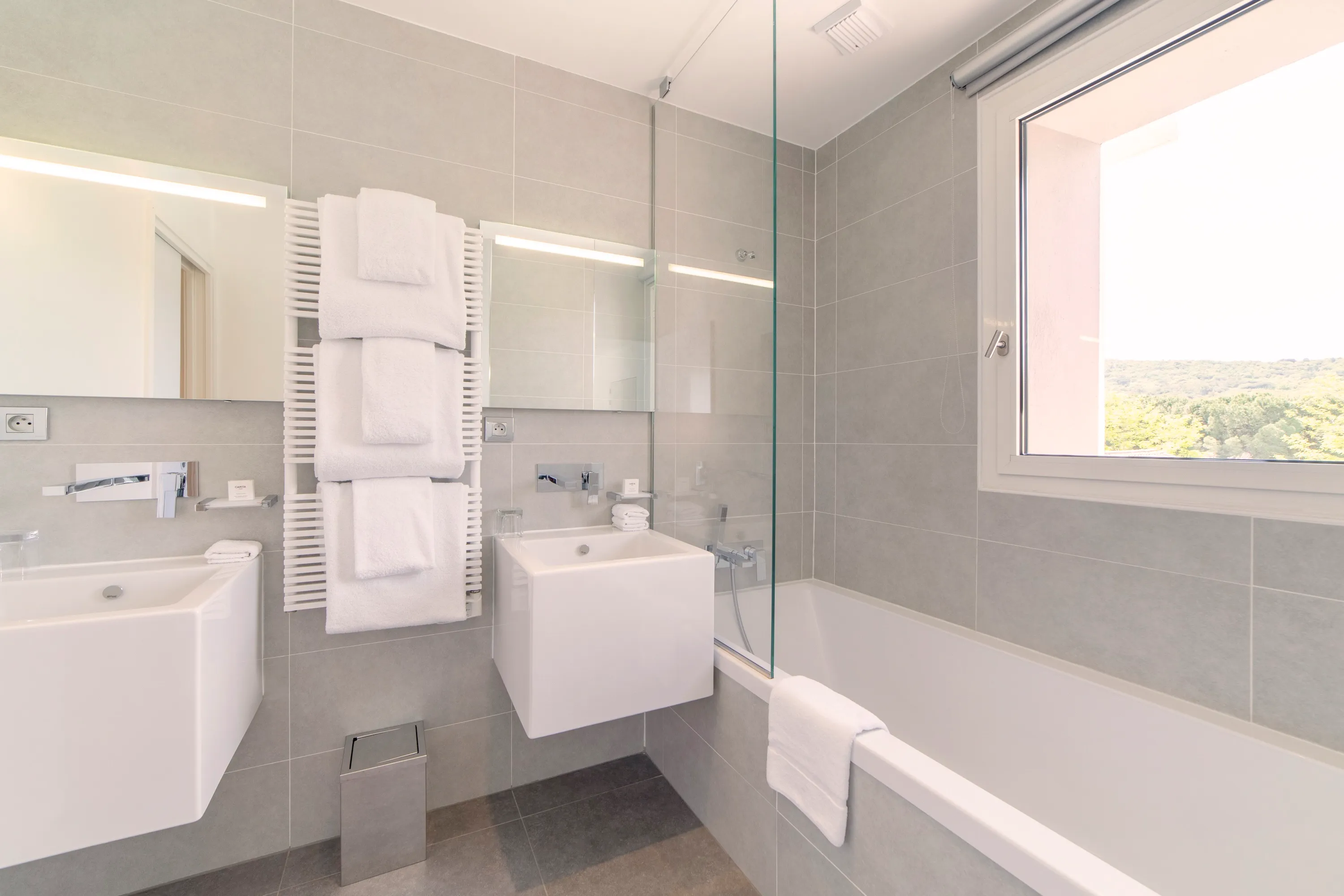 alle de bain moderne et épurée avec double vasque, baignoire et tons gris clairs pour une ambiance zen.